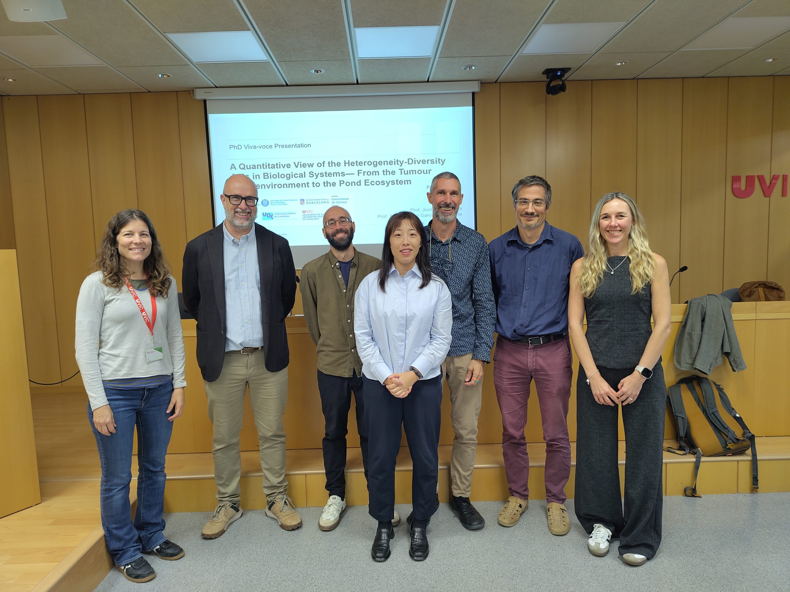 Jing Yang with the members of the examining committee and her supervisors in front of the title slide of her PhD defence