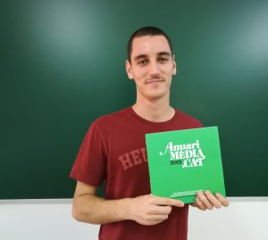 Jan Mompin, sosté un exemplar de l'Anuari MèdiaCat 2021